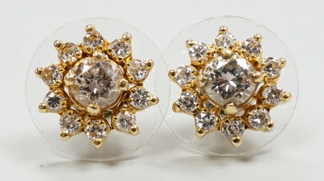 A modern pair of yellow metal and diamond cluster set flower head ear studs, with detachable collars